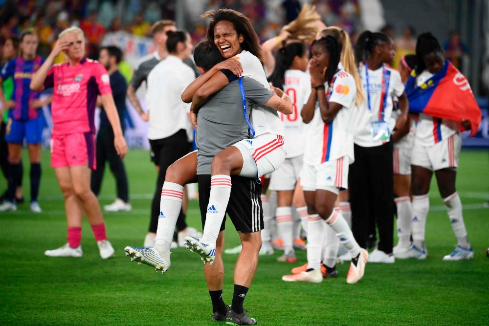Lyon’s French defender Wendie Renard celebrates with a trainer after winning the UEFA Women’s Champions League Final football match between Spain’s Barcelona and France’s Lyon at the Allianz Stadium in the Italian city of Turin on May 21, 2022. AFPPIX