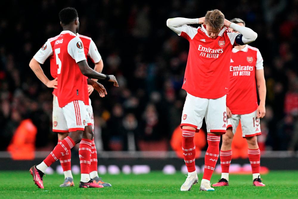 Arsenal midfielder Martin Odegaard (2R) and teammates react after a penalty shoot-out in the UEFA Europa League round of 16, second-leg football match between Arsenal and Sporting Lisbon at the Emirates Stadium in London on March 16, 2023. Sporting Lisbon won the match 5-3 on penalties. AFPPIX