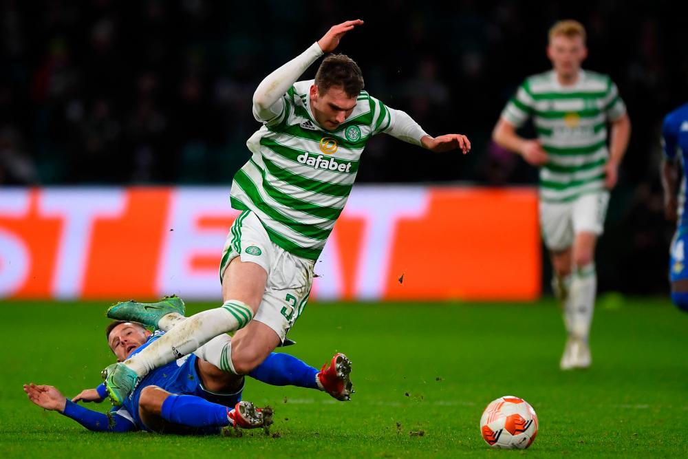 Real Betis' Spanish striker Aitor Ruibal (L) fouls Celtic's English midfielder Liam Shaw (C) during the UEFA Europa League group G football match between Celtic and Real Betis at Celtic Park stadium in Glasgow, Scotland on December 9, 2021. AFPPIX