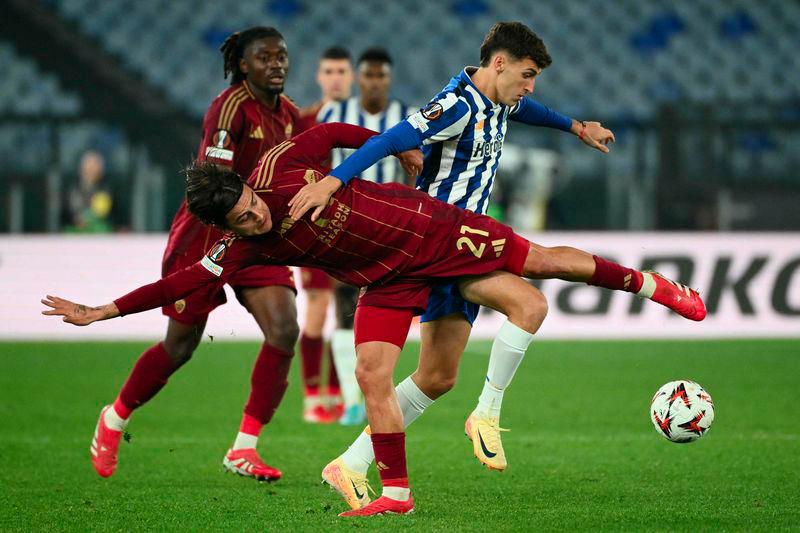 Roma's Argentine forward #21 Paulo Dybala fights for the ball with FC Porto's Argentine midfielder #25 Tomas Perez during the UEFA Europa League knockout round play-off 2nd leg football match between AS Roma and FC Porto at the Olympic stadium in Rome, on February 20, 2025. - AFPPIX