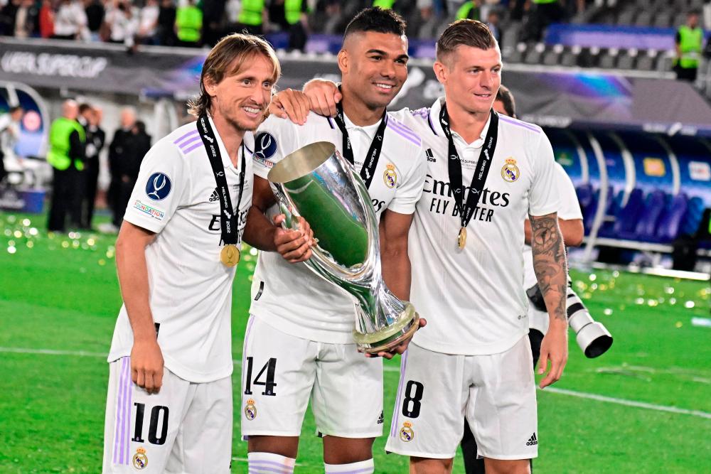 Real Madrid's Croatian midfielder Luka Modric (L-R) Real Madrid's Brazilian midfielder Casemiro and Real Madrid's German midfielder Toni Kroos celebrate with the trophy after the UEFA Super Cup football match between Real Madrid vs Eintracht Frankfurt in HelsinkI/AFPPIX