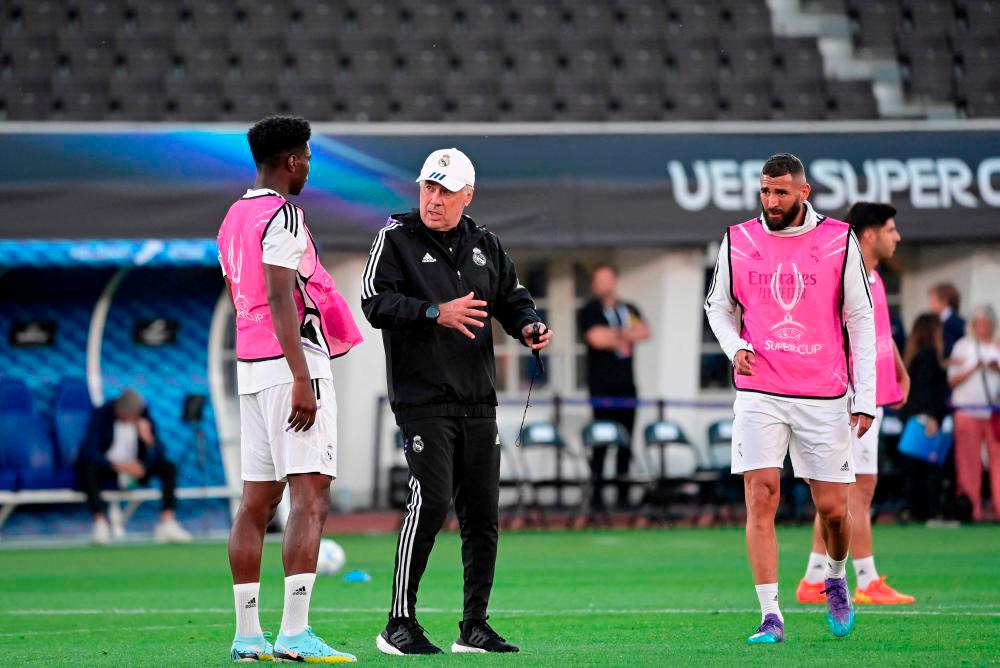 Real Madrid’s Italian coach Carlo Ancelotti (2nd L) speaks to Real Madrid’s French defender Aurelien Tchouameni during a training session on the eve of the UEFA Super Cup football match between Real Madrid vs Eintracht Frankfurt in Helsinki, on August 9, 2022. - AFPPIX