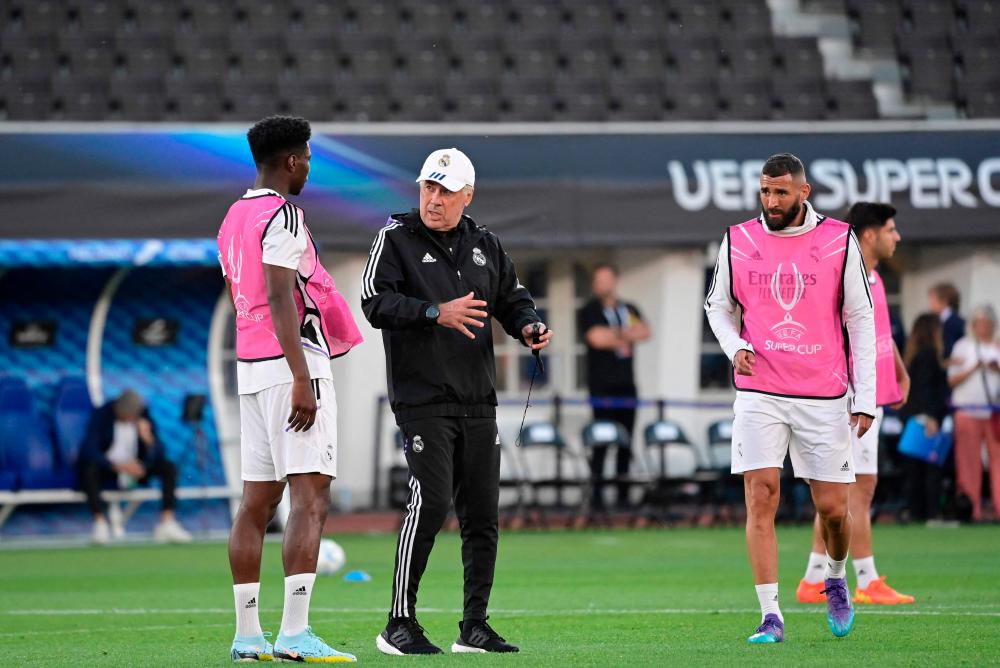 Real Madrid’s Italian coach Carlo Ancelotti (2nd L) speaks to Real Madrid’s French defender Aurelien Tchouameni during a training session on the eve of the UEFA Super Cup football match between Real Madrid vs Eintracht Frankfurt in Helsinki, on August 9, 2022. AFPPIX