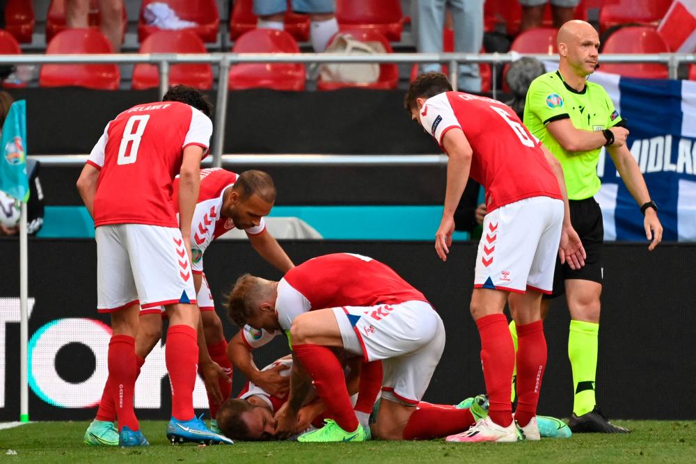 Denmark players help Christian Eriksen after he collapsed before the medics arrive during the UEFA EURO 2020 Group B match against Finland at Copenhagen. – AFPPIX