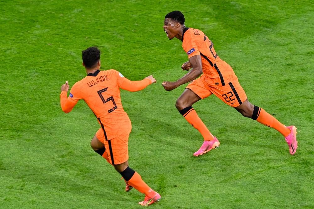 Netherlands’ defender Denzel Dumfries (right) celebrates after scoring the third goal during the UEFA EURO 2020 Group C match at Amsterdam. – AFPPIX