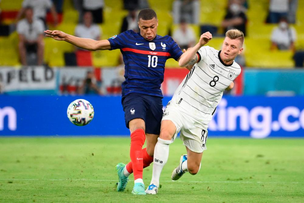 France’s Kylian Mbappe (left) vies for the ball with Germany’s Toni Kroos during the UEFA EURO 2020 Group F match at the Allianz Arena in Munich on June 15, 2021. – AFPPIX