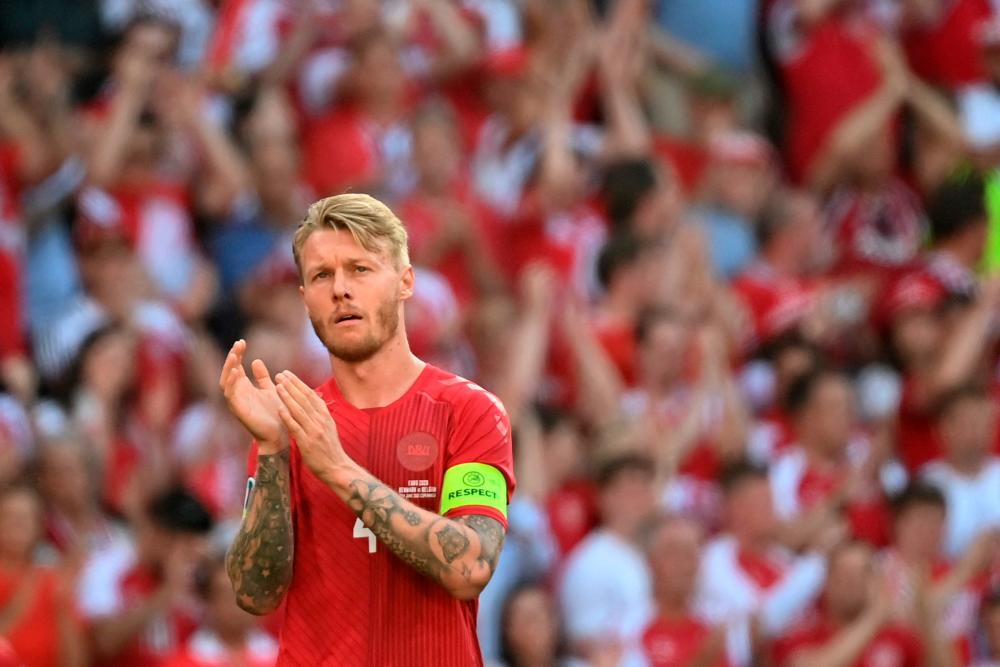 Denmark’s defender Simon Kjaer claps after the ball was kicked out of play in honour of Denmark’s midfielder Christian Eriksen during the UEFA EURO 2020 Group B football match between Denmark and Belgium at the Parken Stadium in Copenhagen on June 17, 2021. -AFP