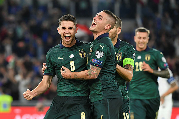 Italy’s midfielder Jorginho (L) celebrates with Italy’s midfielder Marco Verratti after scoring his team’s first goal during the UEFA Euro 2020 Group J qualifier football match between Italy and Greece at the Stadio Olimpico stadium in Rome, on October 12, 2019. — AFP
