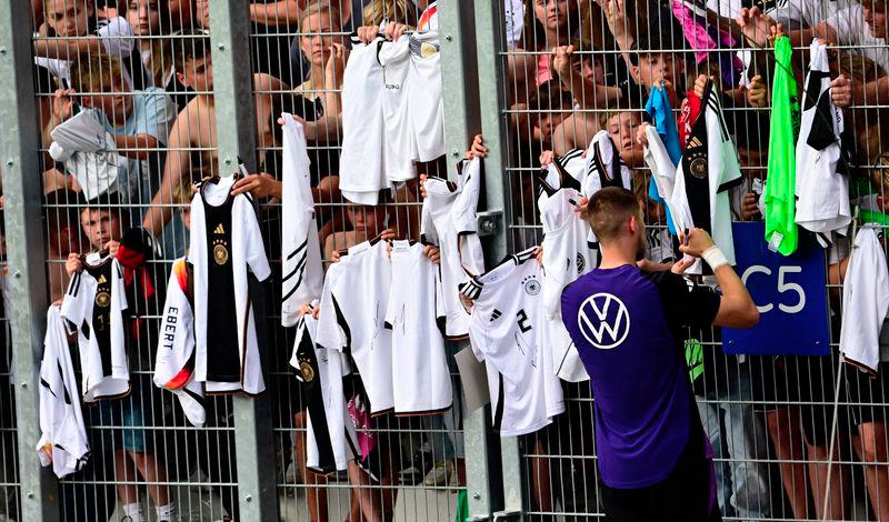 Germany's defender Waldemar Anton signs autographs on shirts for fans at a public training session in Jena, eastern Germany on May 27, 2024. - AFPPIX