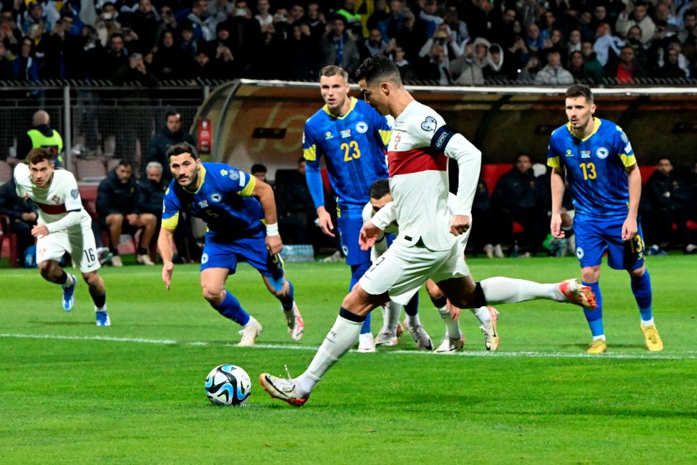 Cristiano Ronaldo shoots from the penalty spot to score the team's first goal during the UEFA Euro 2024 Group J qualification football match Bosnia-Herzegovina v Portugal at the 'Bilino Polje' stadium in Zenica, Bosnia-Herzegovina on October 16, 2023. AFPPIX