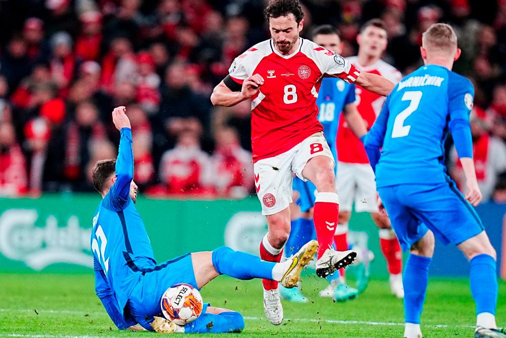 Slovenia's midfielder #22 Adam Cerin (L) and Denmark's midfielder #08 Thomas Delaney (C) vie for the ball during the UEFA Euro 2024 Group H qualification football match between Denmark and Slovenia in Copenhagen on November 17, 2023. - AFPPIX