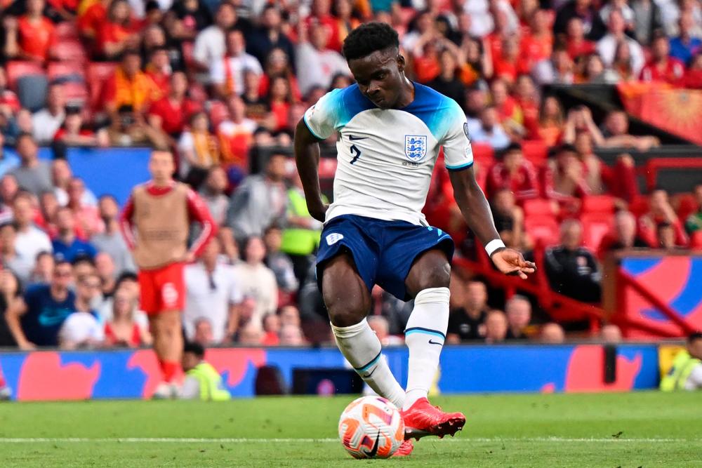 England’s midfielder Bukayo Saka shoots to score his third goal, England’s fifth during the UEFA Euro 2024 group C qualification football match between England and North Macedonia at Old Trafford in Manchester, north west England, on June 19, 2023/AFPPix