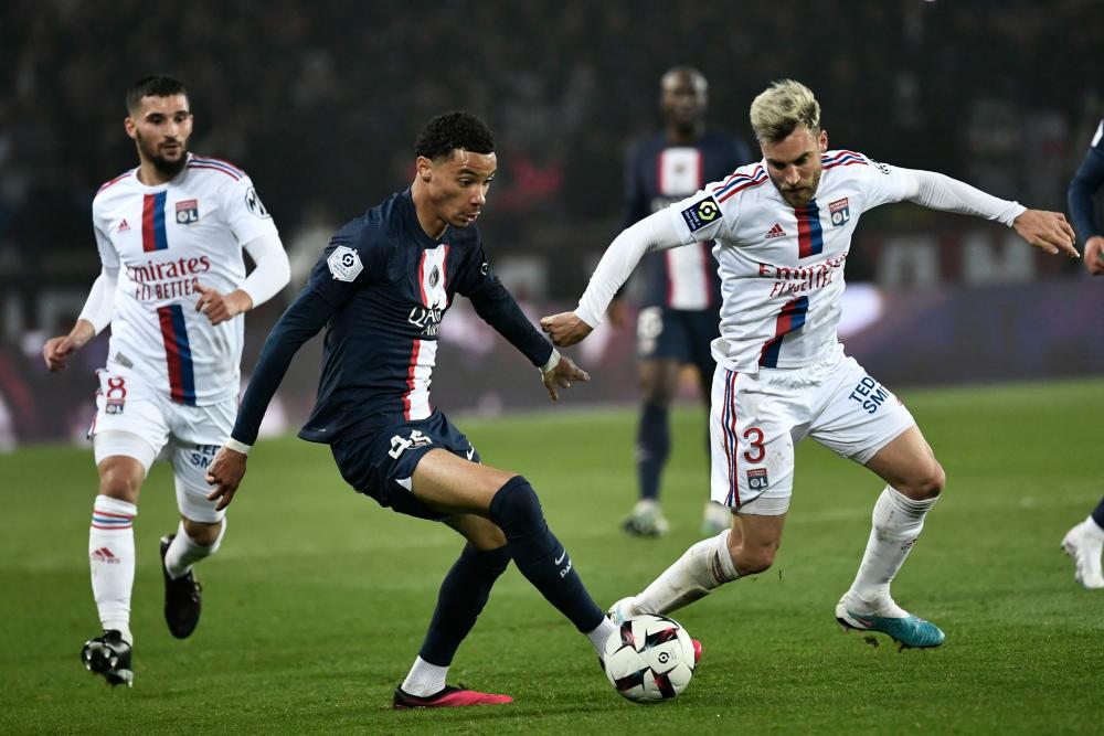 Paris Saint-Germain’s French forward Hugo Ekitike and Lyon’s Argentinian defender Nicolas Tagliafico fight for the ball during the French L1 football match between Paris Saint-Germain (PSG) and Olympique Lyonnais (OL) at The Parc des Princes Stadium in Paris on April 2, 2023/AFPPix