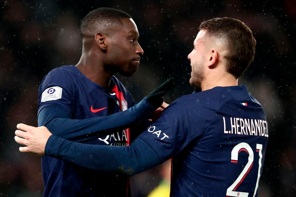 Paris Saint-Germain’s French forward #23 Randal Kolo Muani (L) is congratulated by Paris Saint-Germain’s French defender #21 Lucas Hernandez (R) after scoring a goal during the French L1 football match between Paris Saint-Germain (PSG) and Nantes at the Parc des Princes stadium on December 9, 2023 in Paris/AFPPix