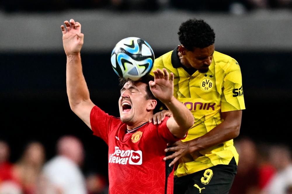 Harry Maguire (L) jumps for the ball with Sebastien Haller during a pre-season friendly football match between Manchester United FC and Borussia Dortmund at the Allegiant Stadium in Las Vegas, Nevada, on July 30, 2023. AFPPIX