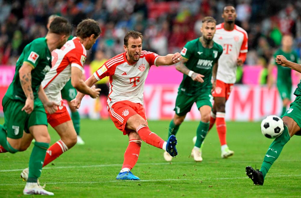 Harry Kane (C) kicks the ball during the German first division Bundesliga football match between FC Bayern Munich and FC Augsburg in Munich, southern Germany on August 27, 2023. AFPPIX