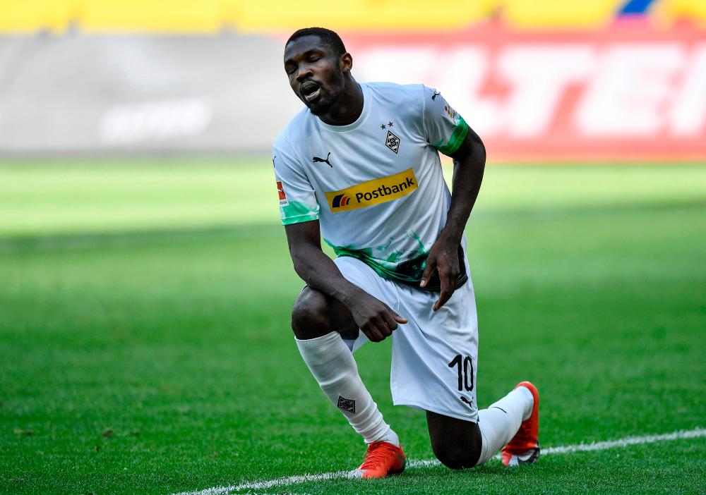 Moenchengladbach’s forward Marcus Thuram takes a knee in protest at the death of an unarmed black man in the United States after scoring during the German Bundesliga match against Union Berlin on May 31, 2020. – AFPPIX