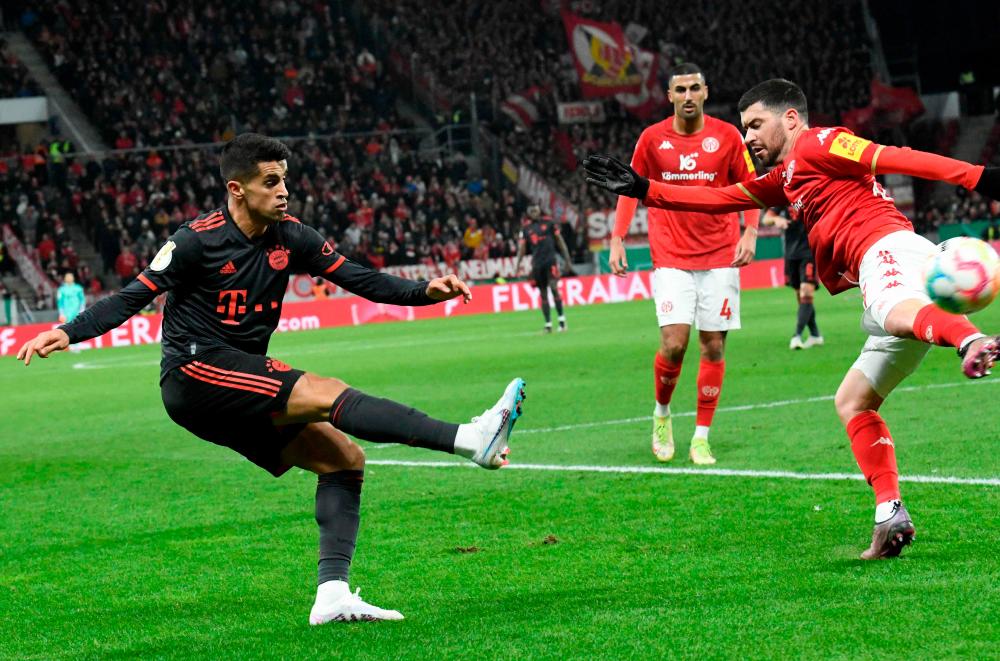 Mainz’ Spanish defender Aaron Martin (R) and Bayern Munich’s Portuguese defender Joao Cancelo vie for the ball during the German Cup (DFB Pokal) last 16 football match between 1 FSV Mainz 05 and FC Bayern Munich in Mainz, southwestern Germany on February 1, 2023. AFPPIX