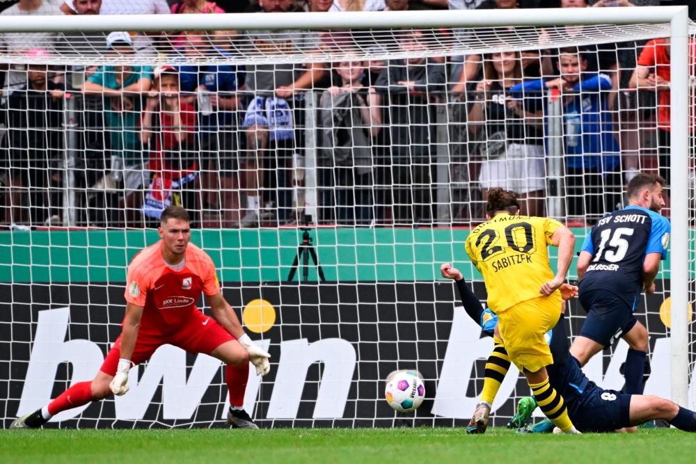 Marcel Sabitzer (R) shoots to score the 4th goal past Schott Mainz’ German goalkeeper #01 Tim Bjarne Hansen during the German Cup 1st round football match between TSV Schott Mainz and Borussia Dortmund in Mainz, western Germany on August 12, 2023. AFPPIX