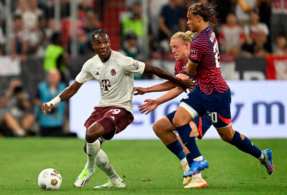 (L-R) Bayern Munich's French forward #39 Mathys Tel, Leipzig's Austrian midfielder #24 Xaver Schlager and Leipzig's Dutch midfielder #20 Xavi Simons vie for the ball during the German Super Cup football match Bayern Munich v RB Leipzig in Munich, on August 12, 2023. - AFPPIX