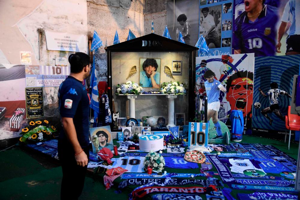 Pictures of late Argentinian soccer player Diego Armando Maradona are displayed among fans items in the Spanish district of Naples on November 25, 2021. -AFPPIX
