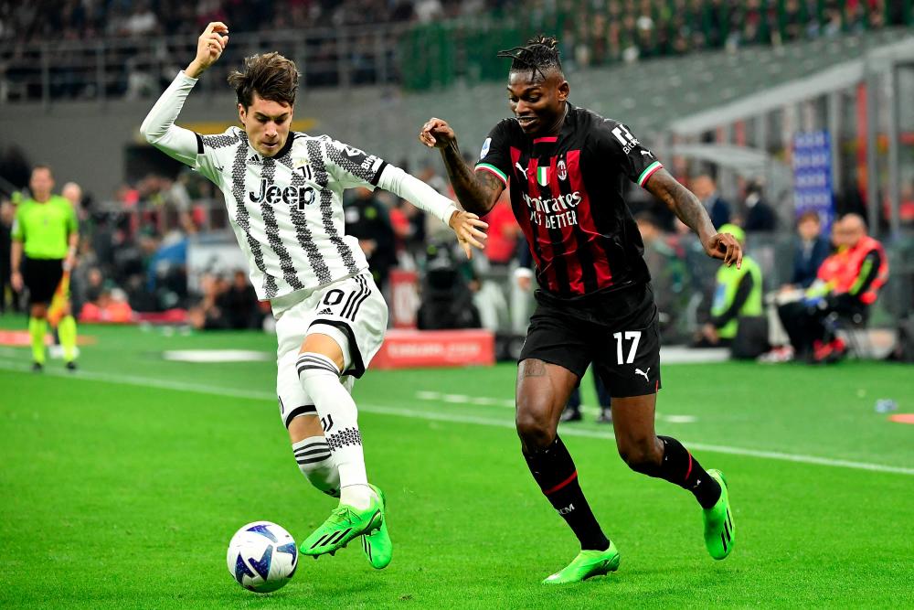 Juventus' Argentinian midfielder Matias Soule (L) fights for the ball with AC Milan's Portuguese forward Rafael Leao during the Italian Serie A football match between AC Milan and Juventus at the San Siro stadium in Milan on October 8, 2022. - AFPPIX