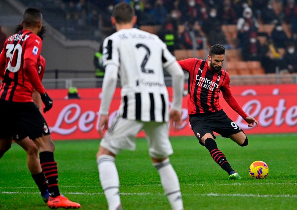 AC Milan’s French forward Olivier Giroud (R) shoots a free kick during the Italian Serie A football match between AC Milan and Juventus on January 23, 2022 at the San Siro stadium in Milan. AFPPIX