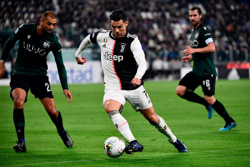 Juventus' Portuguese forward Cristiano Ronaldo (C) challenges Bologna's Brazilian defender Danilo (L) during the Italian Serie A football match Juventus vs Bologna on October 19, 2019 at the Juventus stadium in Turin. - AFP
