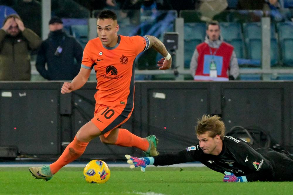 Inter Milan's Argentine forward #10 Lautaro Martinez (R) beats Lazio's Italian goalkeeper #94 Ivan Provedel to score the team's first goal during the Italian Serie A football match Lazio vs Inter Milan on December 17, 2023 at the Olympic stadium in Rome. - AFPPIX