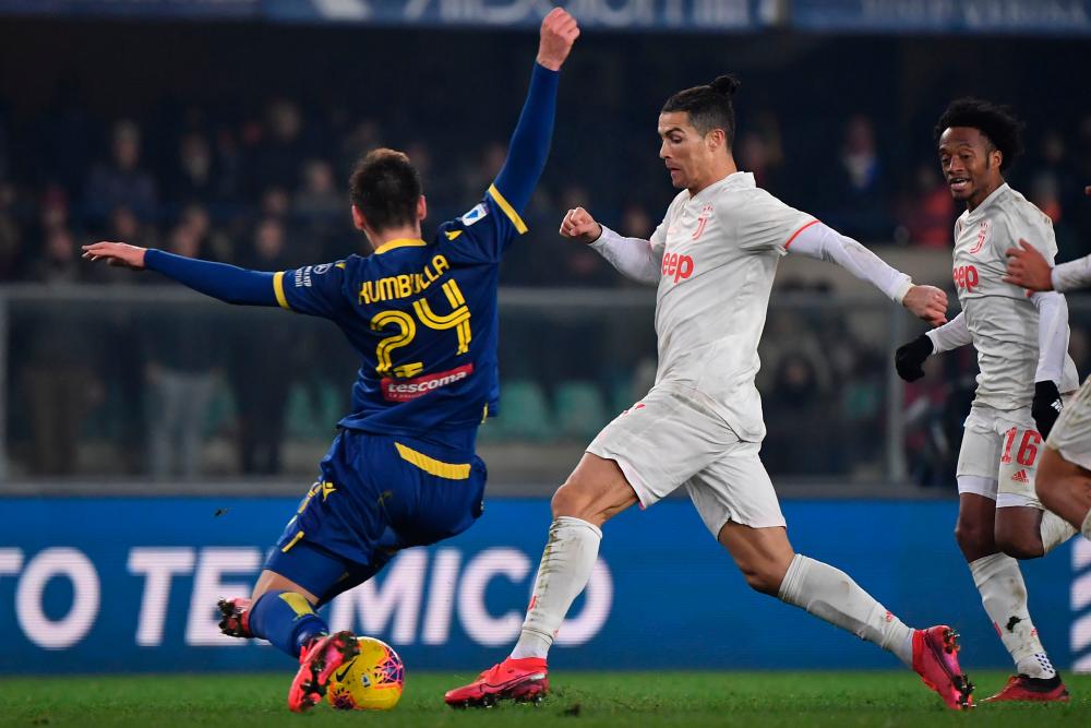 Verona's defender Marash Kumbulla from Italy (L) fights for the ball with Juventus' Portuguese forward Cristiano Ronaldo during the Italian Serie A football match Hellas Verona vs Juventus on Feb 8, 2020, at the Marcantonio Bentegodi stadium in Verona. — AFP