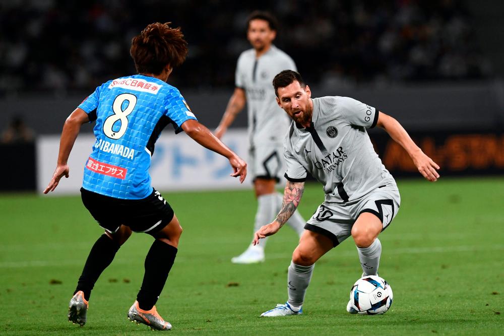 Paris Saint-Germain's Argentinian forward Lionel Messi (R) controls the ball next to Kawasaki Frontale's Japanese midfielder Kento Tachibanada (L) during PSG's Japan Tour football match against Kawasaki Frontale at the National Stadium in Tokyo on July 20, 2022. AFPPIX