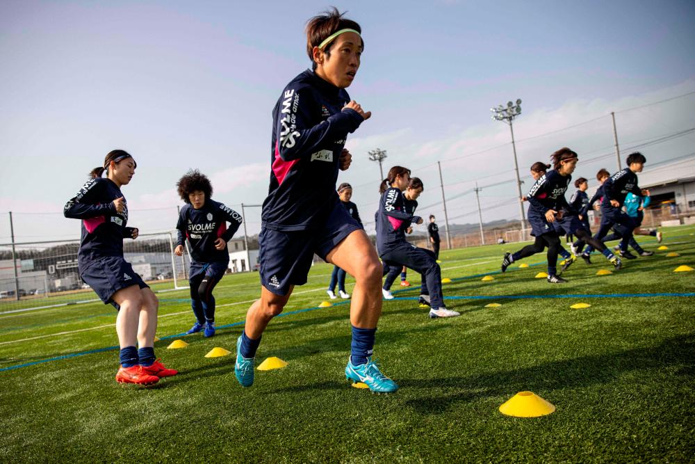 Emi Yamamoto (front) and other players of Japan’s women team Chifure AS Elfen Saitama warming up during a training session in Hanno, Saitama prefecture. &nbsp;– AFPPIX