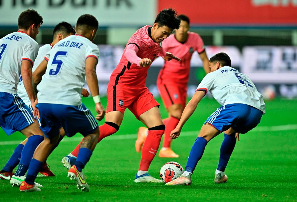 Son Heung-min (centre) dribbles the ball against Chile during a friendly match between South Korea and Chile. - AFPPIX