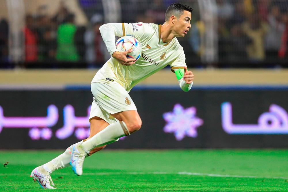 Nassr's forward Cristiano Ronaldo runs with the ball after scoring a penalty during the Saudi Pro League football match between Al-Fateh and Al-Nassr at the Prince Abdullah bin Jalawi Stadium in al-Hasa on February 3, 2023. AFPPIX