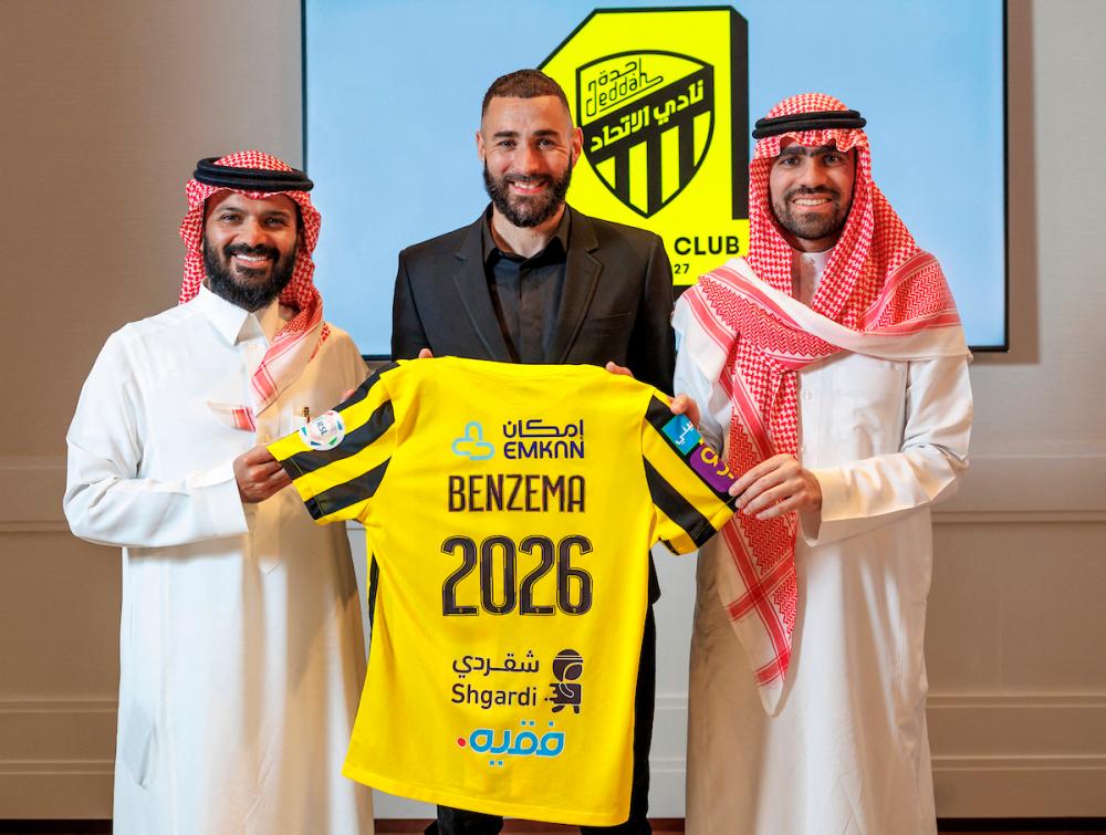 In this handout picture release by the Saudi Pro League on June 6, 2023, French football player Karim Benzema holds the jersey of Saudi Arabia’s Al-Ittihad club as he poses for a picture flanked by Al-Ittihad members, in Madrid. AFPPIX