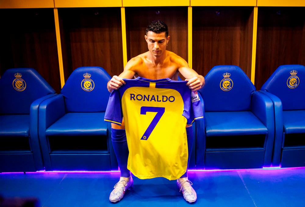 A handout picture released by Saudi Arabia’s al-Nassr football club shows Al-Nassr’s new Portuguese forward Cristiano Ronaldo holding the club’s number seven jersey ahead of his unveiling ceremony at the Mrsool Park Stadium in the Saudi capital Riyadh on January 3, 2023. AFPPIX