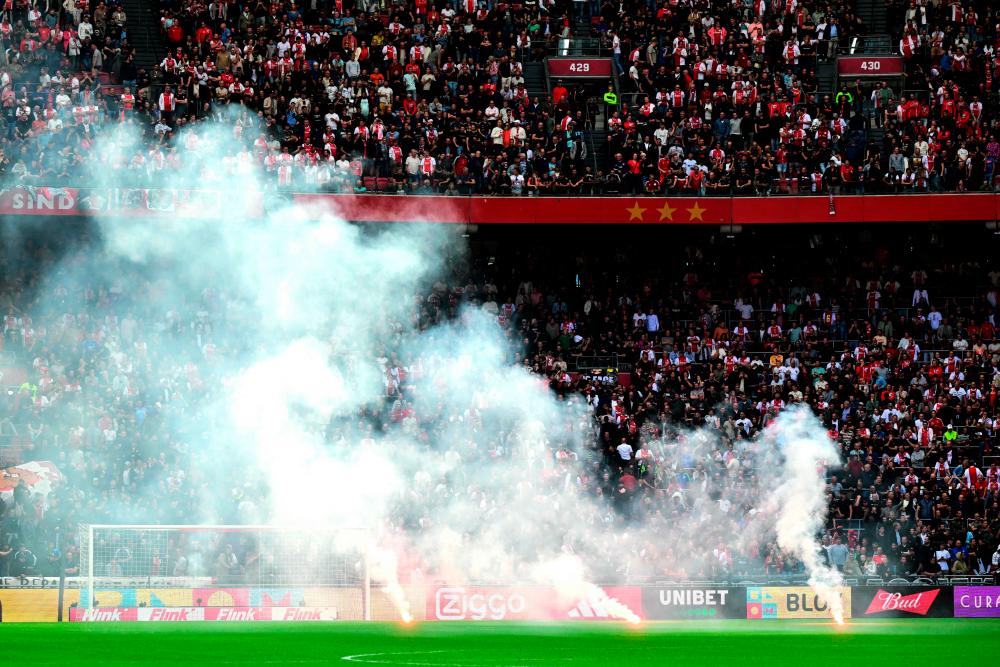 This photograph taken on September 24, 2023, shows smoke rising from fireworks thrown on the field by Ajax’ supporters during the Dutch Eredivisie football match between Ajax Amsterdam and Feyenoord at the Johan Cruijff Arena in Amsterdam. AFPPIX