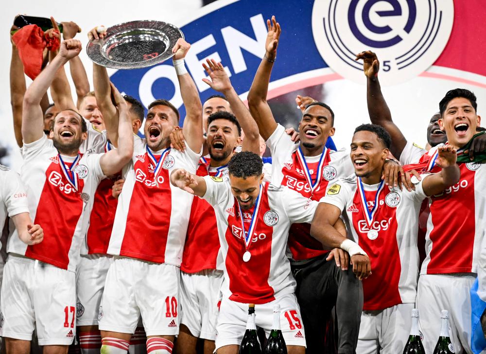 (LtoR) Daley Blind of Ajax, Dusan Tadic of Ajax, Noussair Mazraoui of Ajax, Devyne Rensch of Ajax, Jurrien Timber of Ajax, Edson Alvarez of Ajax celebrate after winning the national championship at the end of the Dutch Eredivisie match between Ajax Amsterdam and SC Heerenveen at the Johan Cruijff Arena on May 11, 2022 in Amsterdam. AFPPIX