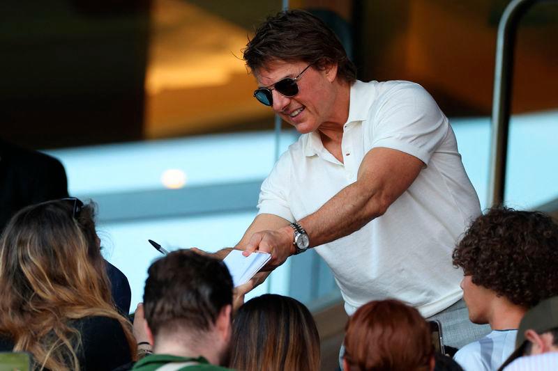 US actor Tom Cruise signs autographs as he attends the women’s gold medal final football match between Brazil and US - AFPpix