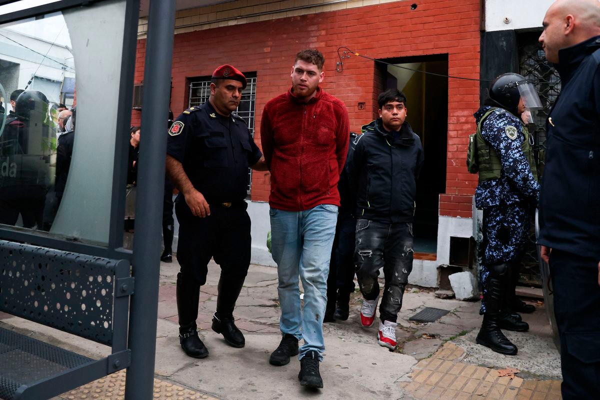 A detained fan of Universidad de Chile is transferred by the Buenos Aires Province Police from a police station in Avellaneda, Buenos Aires province, Argentina on August 21, 2025, after a Copa Sudamericana football match in Buenos Aires between Independiente and visiting Universidad de Chile was abandoned following sustained crowd violence. AFPPix
