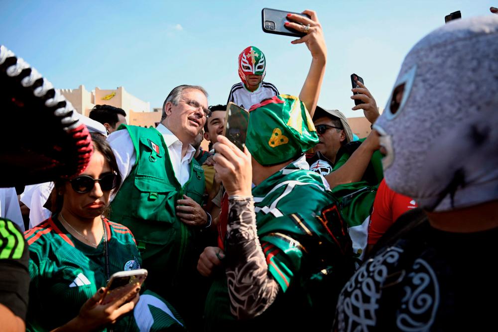$!Mexican Foreign Minister Marcelo Ebrard (centre) poses for pictures with Mexican fans at the Katara Cultura Village during the Qatar 2022 World Cup football tournament in Doha. – AFPPIX