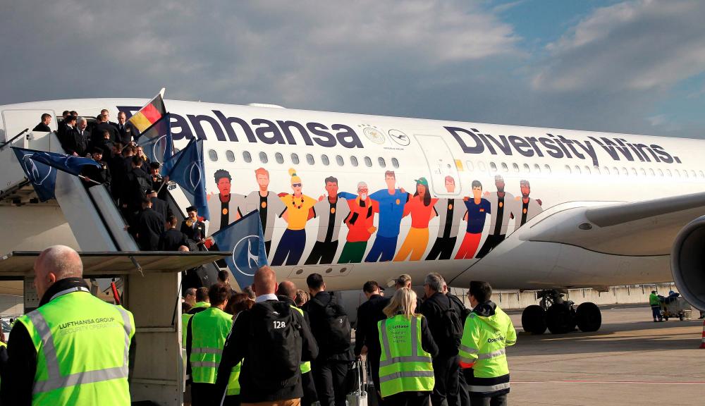 Members of the German national football team pose on the stairs before boarding a Lufthansa plane decorated with the lettering “Diversity Wins”. – AFPPIX $!Members of the German national football team pose on the stairs before boarding a Lufthansa plane decorated with the lettering “Diversity Wins”. – AFPPIX
