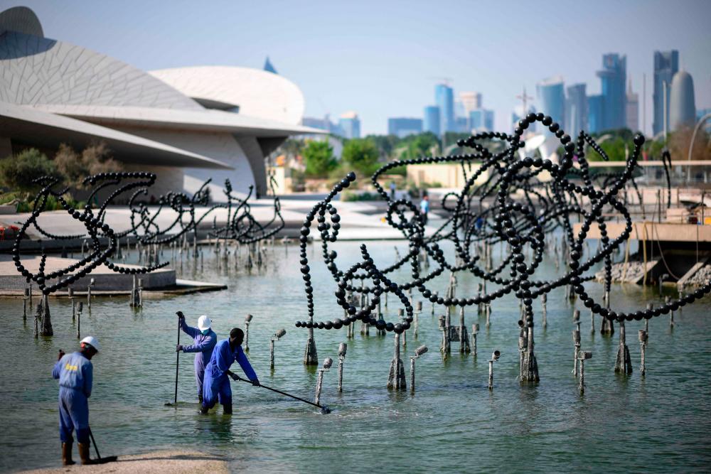 Labourers work in front of the National Museum of Qatar in Doha on November 14, 2022, ahead of the Qatar 2022 World Cup football tournament. AFPPIX