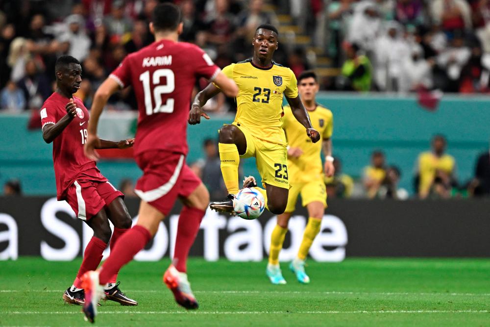 Ecuador's midfielder Moises Caicedo controls the ball next to Qatar's forward Almoez Ali (L) and Qatar's midfielder Karim Boudiaf during the Qatar 2022 World Cup Group A match between Qatar and Ecuador at the Al-Bayt Stadium in Al Khor, north of Doha on November 20, 2022. AFPPIX