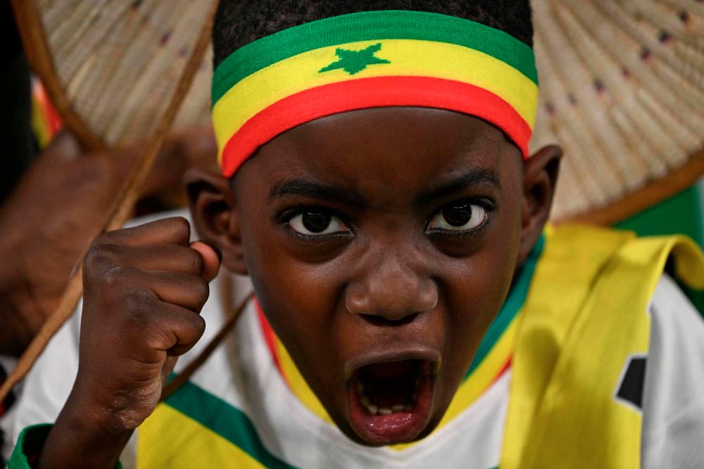 $!A young Senegal fan cheers prior to the Group A match. – AFPPIX