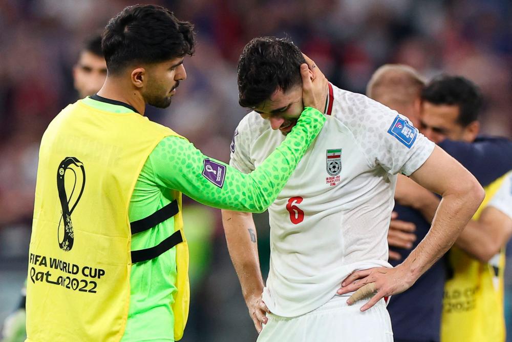 Iran’s midfielder #06 Saeid Ezatolahi (R) cries as he is comforted by Iran’s goalkeeper #22 Amir Abedzadeh at the end of the Qatar 2022 World Cup Group B football match between Iran and USA at the Al-Thumama Stadium in Doha on November 29, 2022/AFPPix