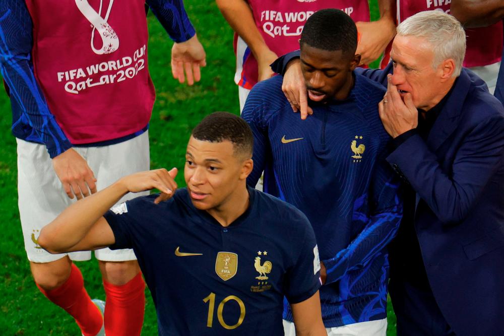 France's Kylian Mbappe, Ousmane Dembele and France's coach Didier Deschamps celebrate at the end of the Qatar 2022 World Cup round of 16 football match between France and Poland at the Al-Thumama Stadium in Doha on December 4, 2022. AFPPIX