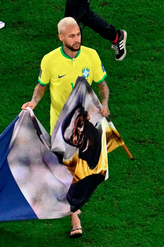 Brazil's forward Neymar holds a banner dedicated to banner Brazilian football legend Pele at the end of the Qatar 2022 World Cup round of 16 football match between Brazil and South Korea at Stadium 974 in Doha on December 5, 2022. AFPPIX