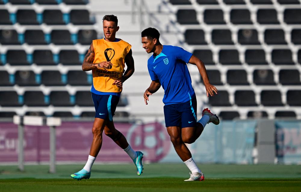 FILE PHOTO: .Ben White (L) and Jude Bellingham attend a training session at Al Wakrah SC Stadium in Al Wakrah, south of Doha on November 24, 2022, on the eve of the Qatar 2022 World Cup football match between England and USA. AFPPIX