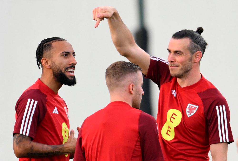 Wales’ forward Gareth Bale (R) jokes with midfielder Sorba Thomas (L) during a training session at the Al Sadd SC in Doha on November 17, 2022, ahead of the Qatar 2022 World Cup football tournament. AFPPIX